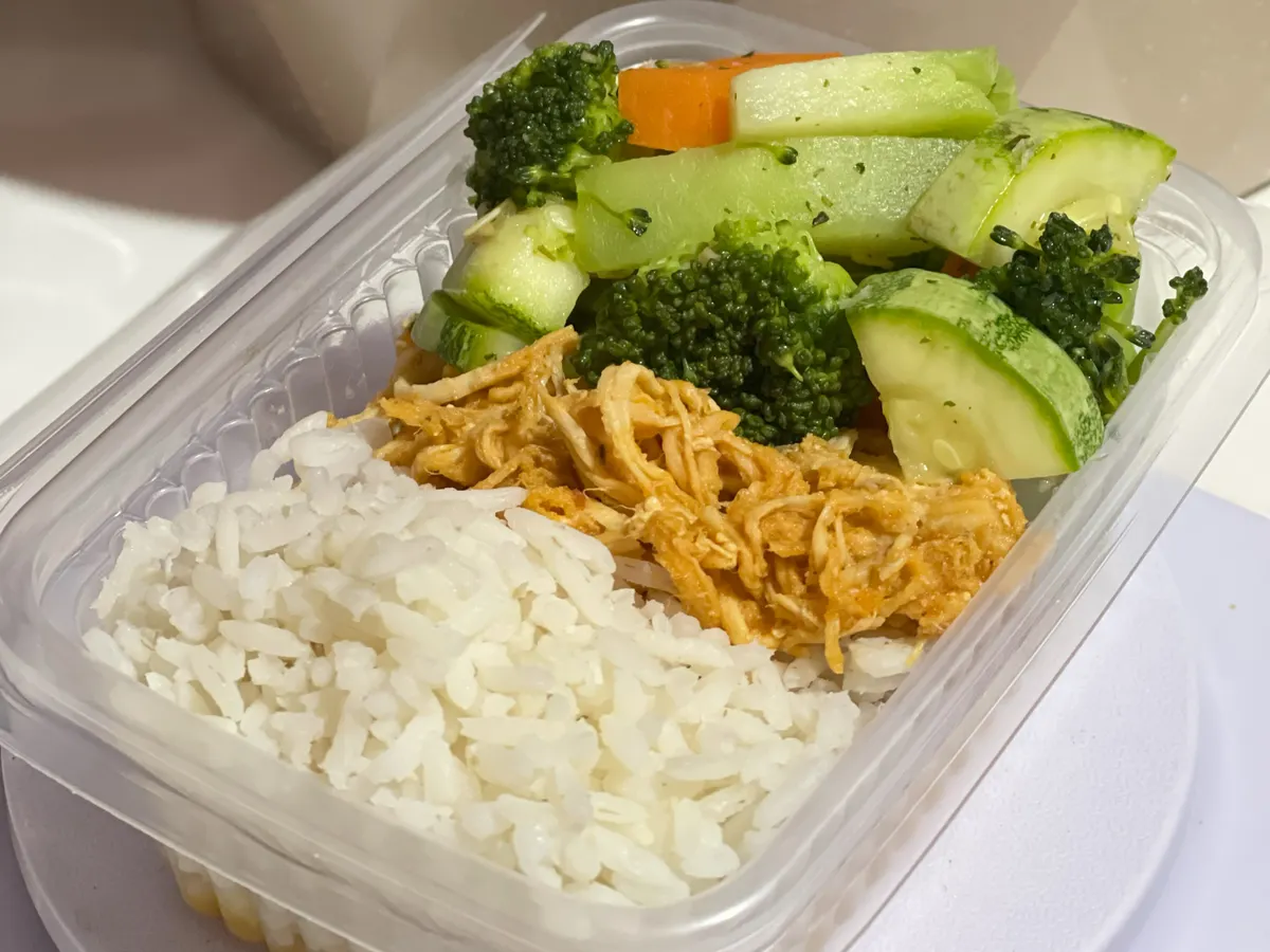 Boîte repas avec du riz, du poulet effiloché et des légumes