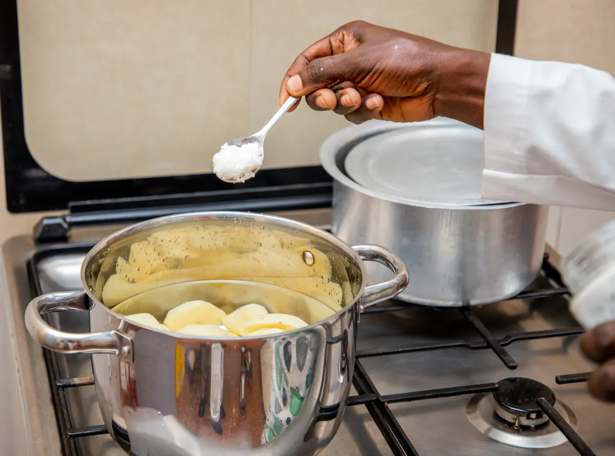 Pincée de sel au-dessus d'une casserole