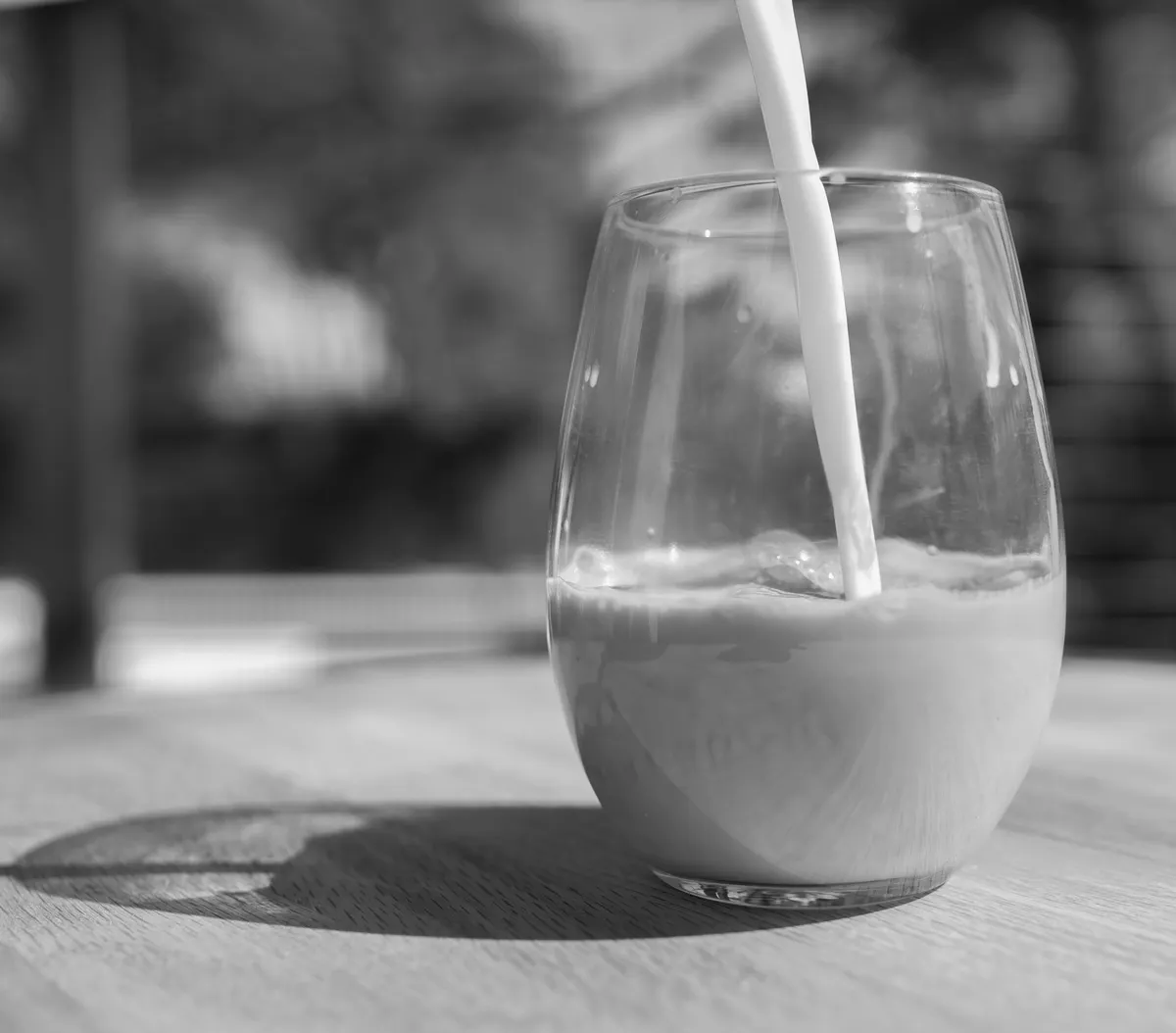 Lait versé dans un verre, en noir et blanc