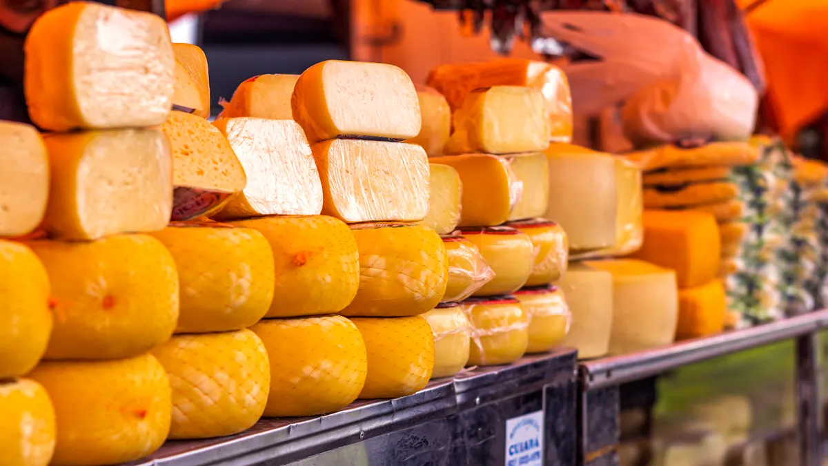 Fromages entamés emballés dans du papier sur un étal