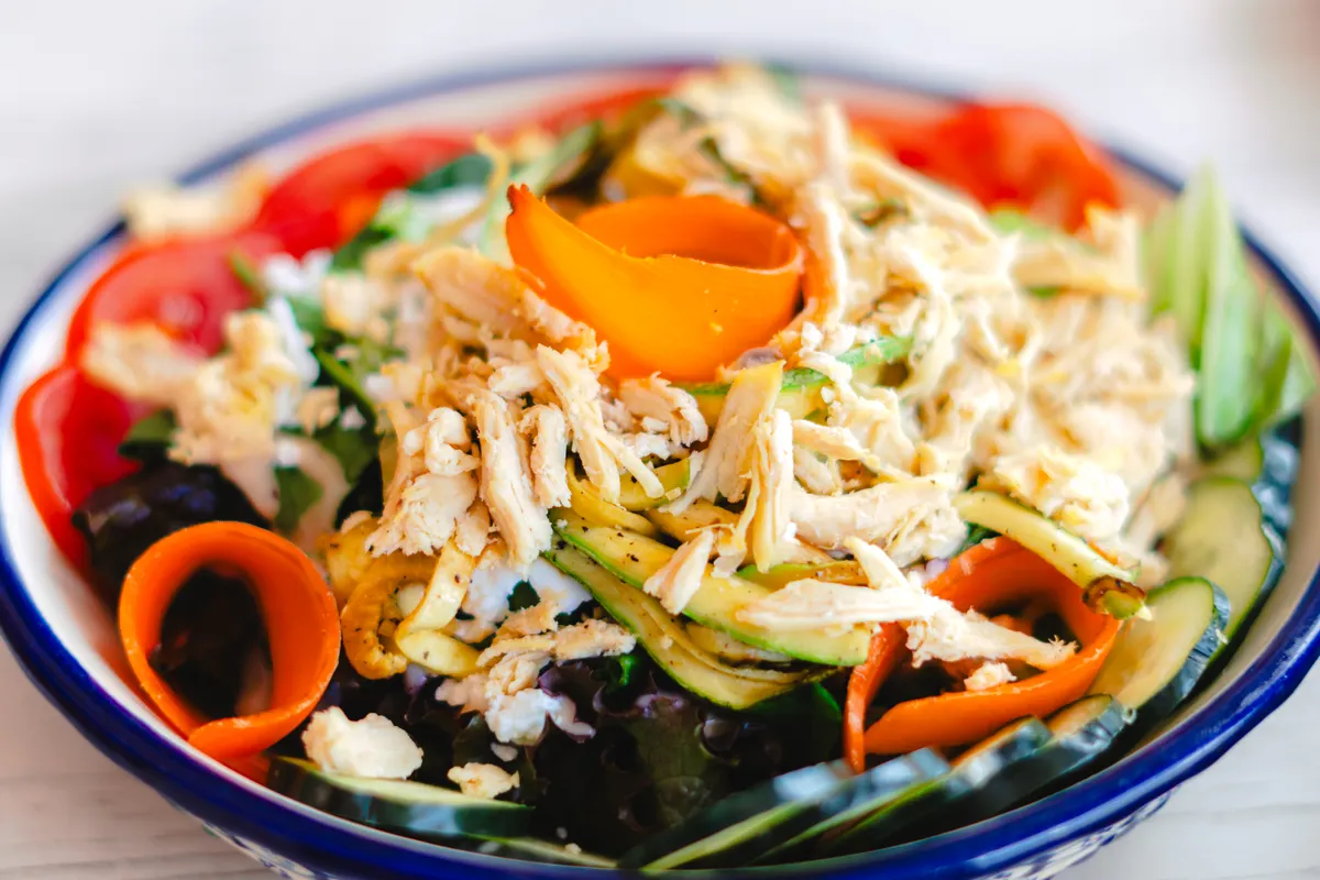 Salade composée avec du poulet effiloché et des légumes
